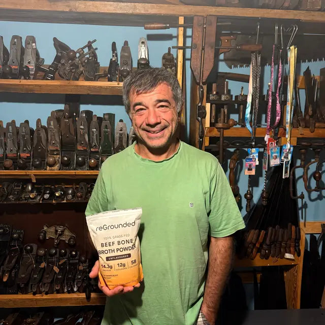 reGrounded customer holding his beef bone broth pouch in his workshop